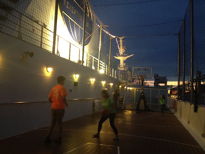 SAS12 | Abroad101 Blog Students playing basketball at dusk on the Semester at Sea ship’s onboard court under protective netting and deck lights