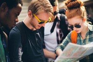 Students Exploring a New City While Studying Abroad | Abroad101 Blog Four young travelers looking at a city map together outdoors.