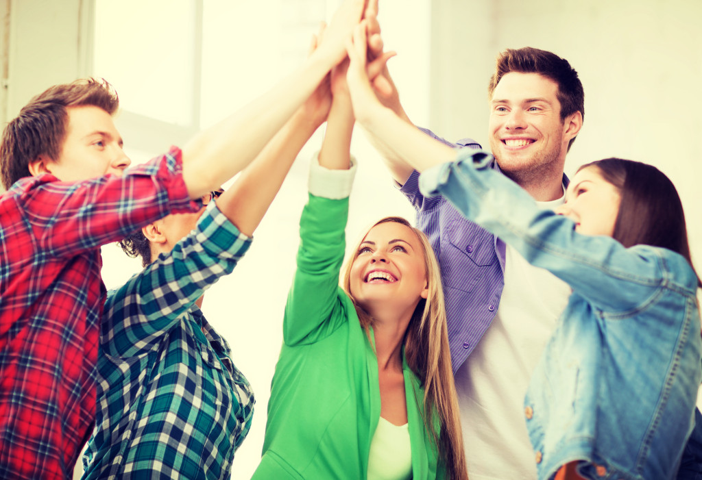 happy students giving high five at school | Abroad101 Blog education and friendship concept - happy students giving high five at school