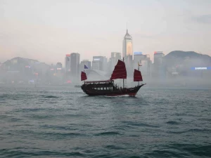 Hong Kong tufts | Abroad101 Blog Traditional junk boat sailing in front of Hong Kong's skyline, symbolizing the fusion of local culture and global educational influences, as seen in UK primary schools in Hong Kong.
