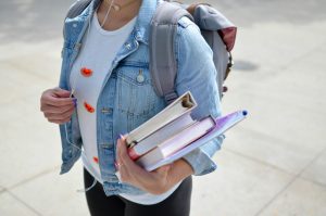element5-digital-jCIMcOpFHig-unsplash | Abroad101 Blog Graduate student in denim jacket with backpack and notebooks in hand, heading out to conduct research interviews abroad.