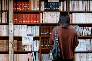 Student browsing books in a foreign library, symbolizing cultural immersion and academic exploration during a study abroad experience.