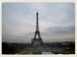 Wide view of the Eiffel Tower rising above Paris on an overcast day—an iconic backdrop for students planning to study abroad in France.