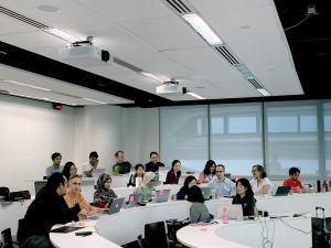 Diverse group of students in a modern tiered classroom using laptops and sharing ideas—highlighting collaborative learning and academic integrity in global settings.