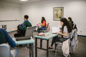 pexels-rdne-7092350 | Abroad101 Blog Students sit at separate desks in a classroom, each quietly focused on individual study materials, highlighting the isolation of solo learning.
