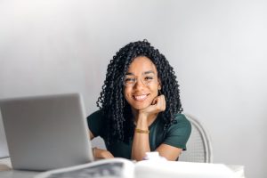 pexels-olly-3769021 | Abroad101 Blog Student smiling at laptop while researching Financial Aid options.