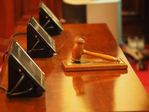 12 | Abroad101 Blog Judge’s gavel on a wooden desk beside delegate panels, representing UK law schools and legal education.