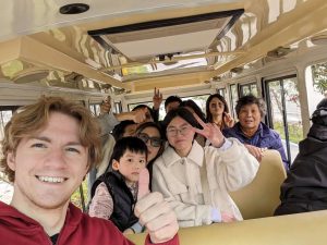 P | Abroad101 Blog Intern in China takes a selfie on a shuttle while mingling with local residents—smiles and peace signs—showcasing cultural immersion during a paid internship.