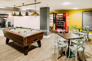 junxin | Abroad101 Blog Common room in Edinburgh student housing with pool table, vending machines, and seating.