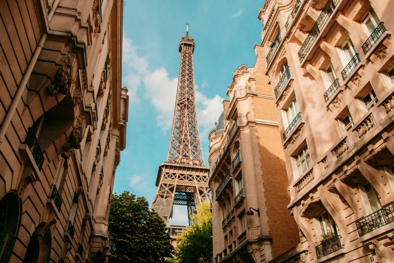 Eiffel Tower framed by classic Haussmann apartment buildings in Paris—study abroad students can find furnished rentals and bypass the French guarantor requirement with digital guarantor platforms.