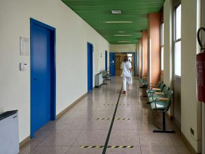 pexels-serenakoi-13018111 | Abroad101 Blog Student walking down a hospital or clinic hallway with waiting chairs, representing navigating healthcare facilities and appointments while studying abroad.
