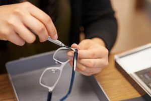 unnamed (11) | Abroad101 Blog Close-up of someone repairing broken eyeglasses with a small screwdriver.