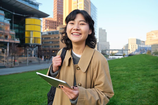 Student holding a notebook on an international campus, representing Singapore-style education, global learning, and study abroad pathways.